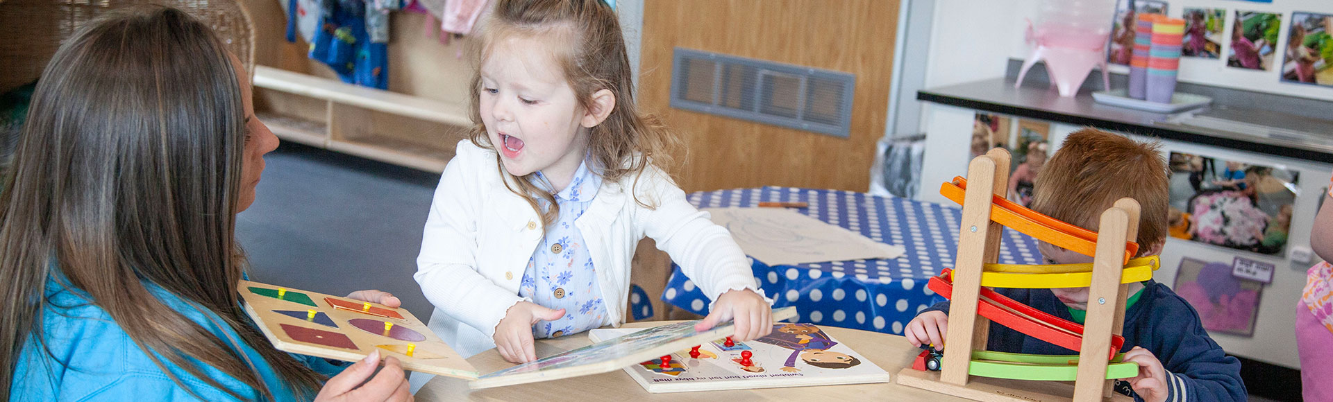 Young girl playing with wooden shape puzzles